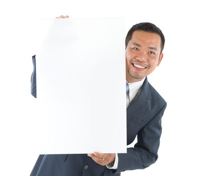 Smiling asian business man holding blank billboard.