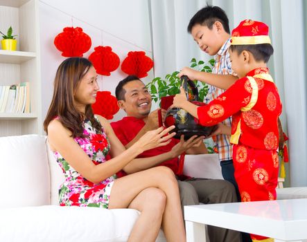 Asian boys presenting gift basket to parents on chinese new year