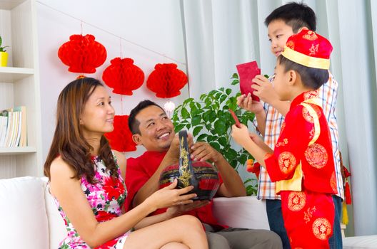 Asian boys presenting gift basket to parents on chinese new year