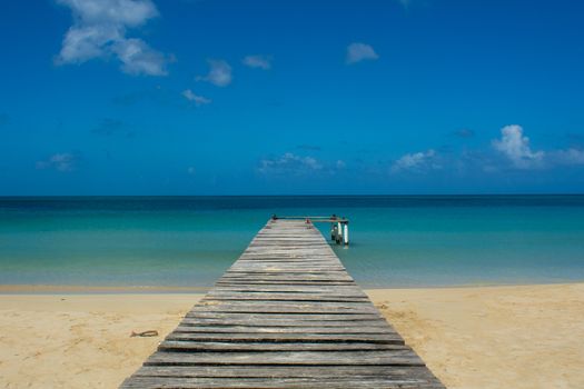 Small pier on a beach in caribbean tropical island