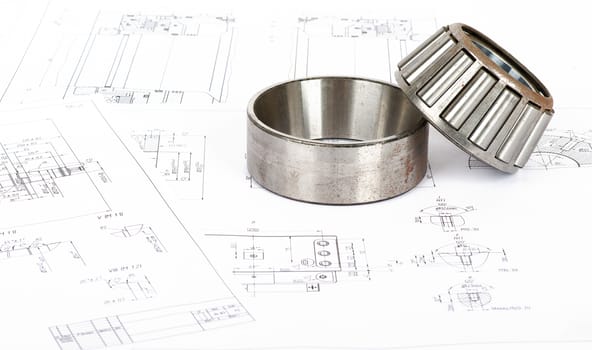 Roller bearing on blue prints, close up view