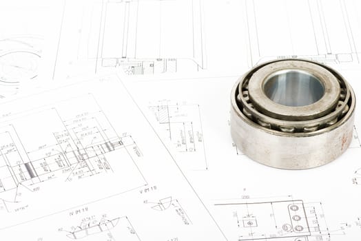 Roller bearing on blue prints, close up view