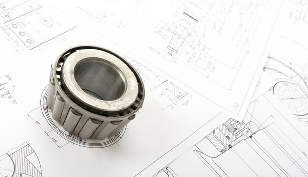Roller bearing on blue prints, close up view