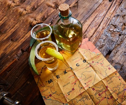 Tequila shot with lime and sea salt on wooden table, selective focus