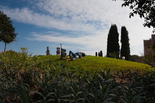 BARCELONA, SPAIN, february 2016- man with a trolley resting on the glade in Parc del Clot