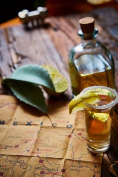 Tequila shot with lime and sea salt on wooden table, selective focus