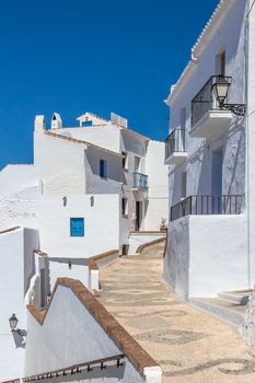 Traditional Andalusian white houses under blue sky. Frigiliana, Spain.