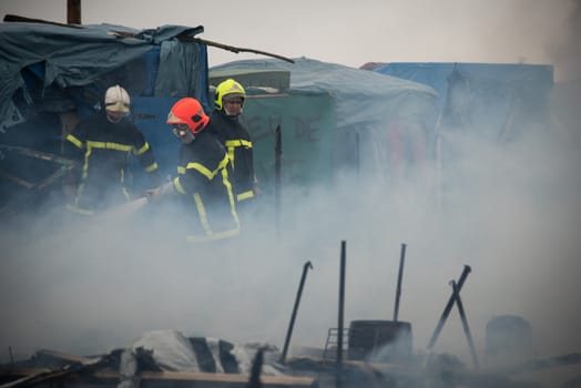 FRANCE, Calais: Three firemen try to stop a fire burning shacks, in the southern part of the so-called Jungle migrant camp, as half of the camp is being dismantled, in the French northern port city of Calais, on March 1, 2016. 
In the northern French port city of Calais, tensions were high as officials for a second day razed part of the Jungle camp, which has become a magnet for people hoping to reach Britain.