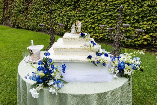 Big wedding cake on a table on the grass