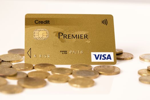 Credit card payment concept : Golden credit card with coins in white background.