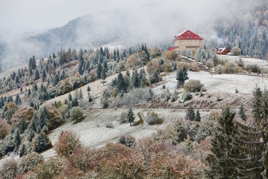 Hotel in mountains. Snow and fog. Winter coming in Carpathians.