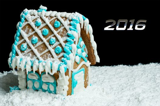 Gingerbread house and number 2016 over black background