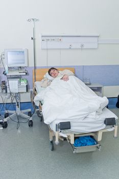 Young woman in hospital ward and monitoring medical equipment