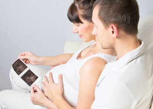 Young couple looking at their baby ultrasound picture