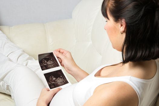 Pregnant woman looking at her baby ultrasound picture