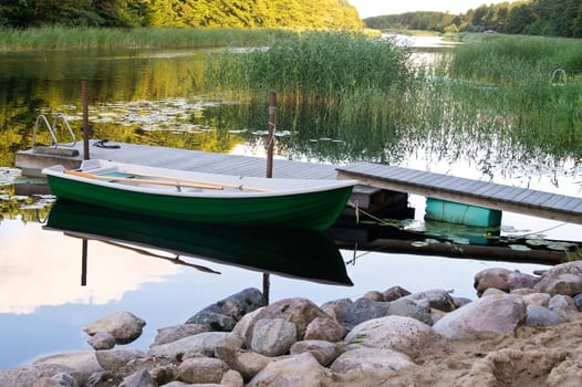 Rowboat stored near wooden jetty on river