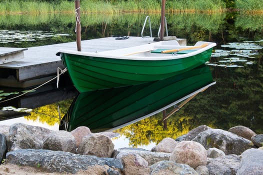 Green rowboat near dummy on river