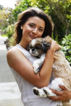 Portrait of a beautiful brunette with dog outdoors