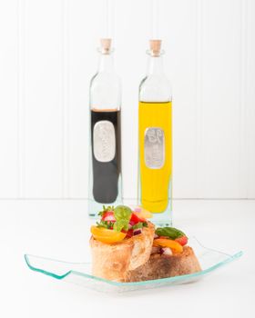 Colorful bruschetta with bottles of olive oil and balsamic vinegar.  Suitable for numerous food service applications.