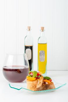 Colorful bruschetta and red wine.  Suitable for a variety of food service promotional applications.