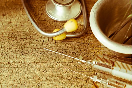 Vintage style, Old medical syringes , hypodermic needles and stethoscope on old wood background