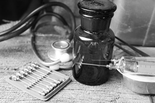 Black and white style, Old medical syringes , hypodermic needles and stethoscope on old wood background