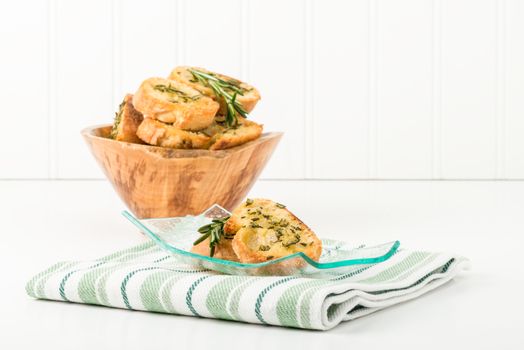 Rosemary and olive oil crostini on a glass plate.  Useful for many food service marketing applications.