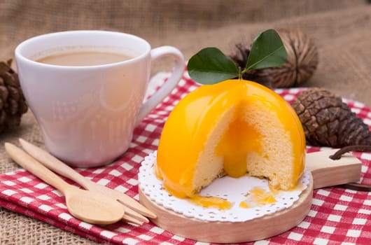 Orange cake with orange form and coffee cup