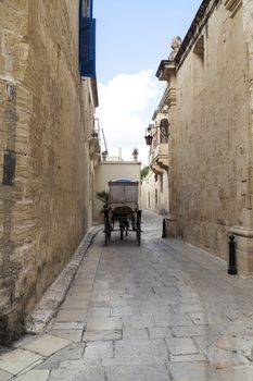 Typical narrow street with cab  in the medieval town Mdina, Malta, Europe