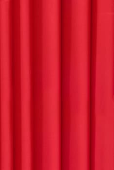 Bright red fabric, draped vertical folds of the curtain.