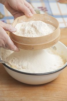 Women's hands prepairing flour before baking pie.