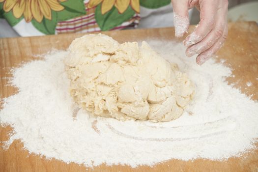 Women's hands prepairing fresh yeast dough.