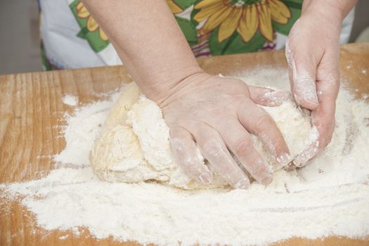 Women's hands prepairing fresh yeast dough.