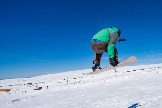 Snowboarder executing a radical jump against blue sky.