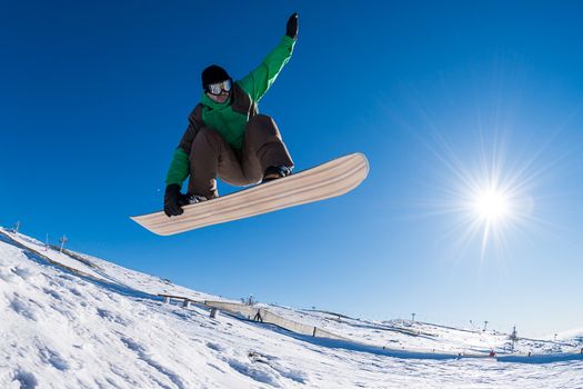 Snowboarder executing a radical jump against blue sky.