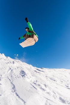 Snowboarder executing a radical jump against blue sky.