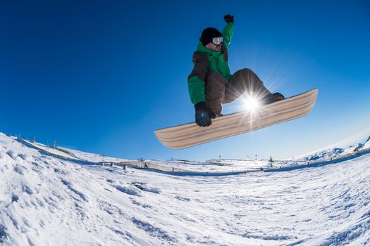 Snowboarder executing a radical jump against blue sky.