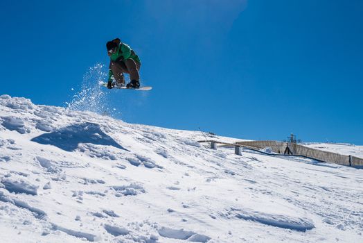 Snowboarder executing a radical jump against blue sky.