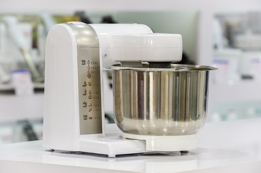 single electric food processor at retail store shelf, defocused background