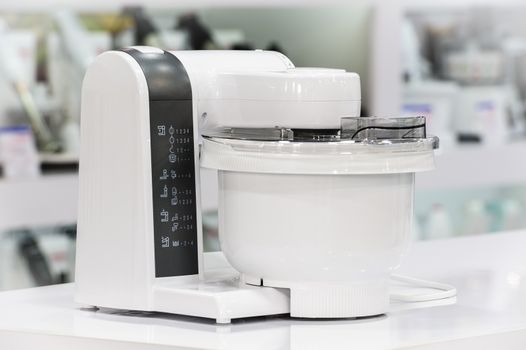 single electric food processor at retail store shelf, defocused background