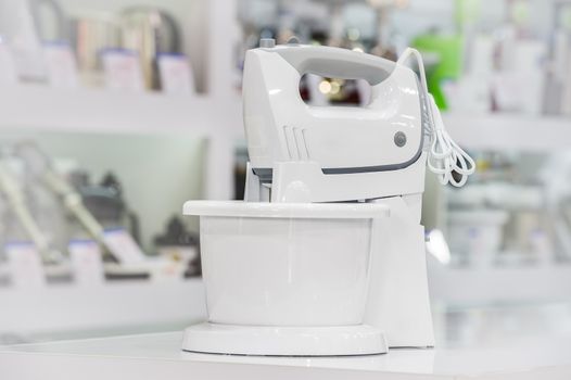 single electric food processor at retail store shelf, defocused background