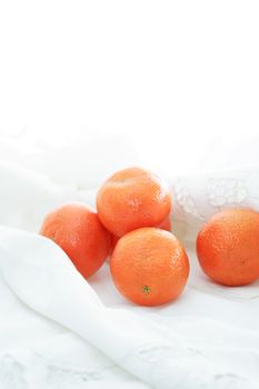 Good morning concept. Few tangerines on white textile