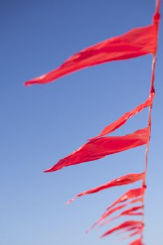 small red flags in wind against blue sly