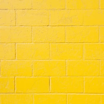 square part of bright yellow painted brick block wall
