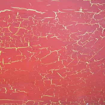 square surface with red cracked paint on yellow background