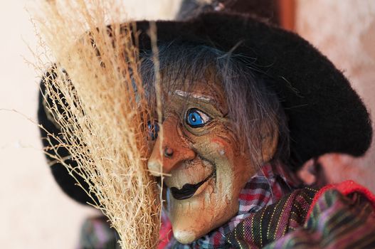 Portrait of a witch doll with a hat and broom