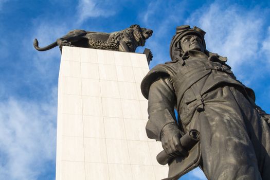 Statues of a lion as a symbol of Czechoslovakia and Milan Rastislav Stefanik as an important politician. Blue sky with intense contrast clouds. Bratislava, Slovakia