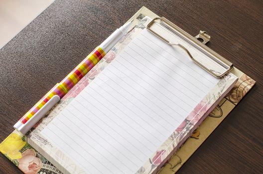 Notebook and pen on wood table