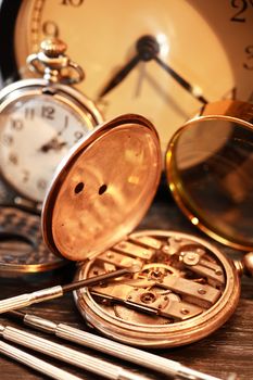 Hour workshop. Vintage still life with ancient silver pocket watch and tools