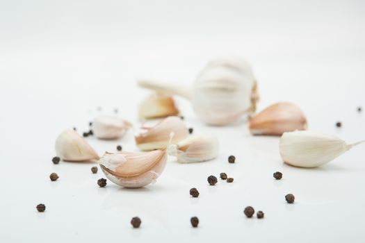 many cloves of garlic on white background,pepper